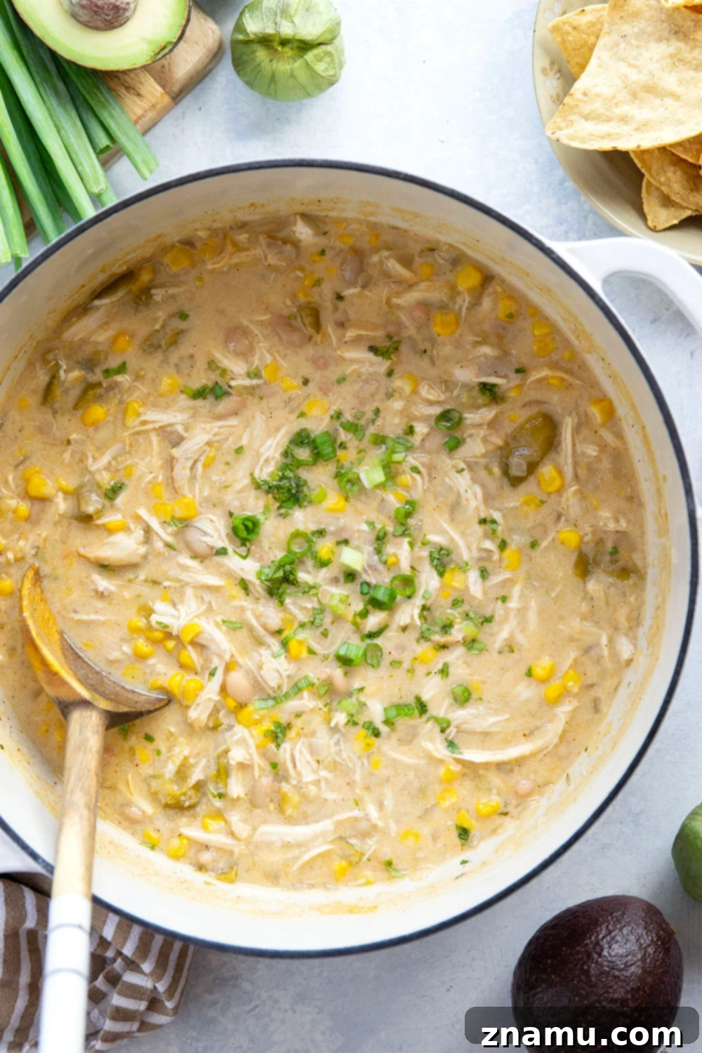 Smoky Verde Chicken Chili 2 A vibrant bowl of Tomatillo White Chicken Chili, garnished with fresh cilantro, avocado, and a dollop of sour cream, highlighting the rich and creamy texture.