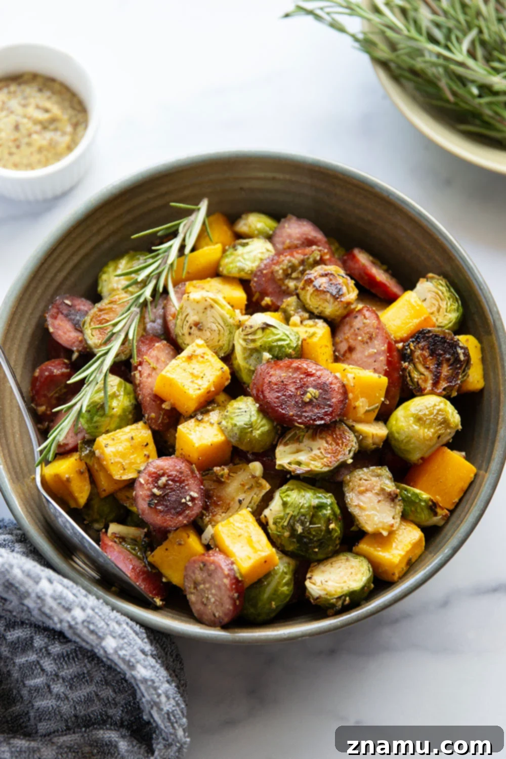Rustic Sausage and Butternut Sheet Pan Dinner 3 Overview of a sheet pan filled with uncooked sausage, butternut squash, and brussels sprouts before roasting.