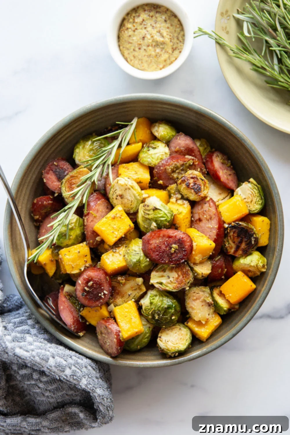 Rustic Sausage and Butternut Sheet Pan Dinner 5 Roasted chicken or turkey sausage slices with butternut squash and brussels sprouts on a sheet pan, ready to serve.