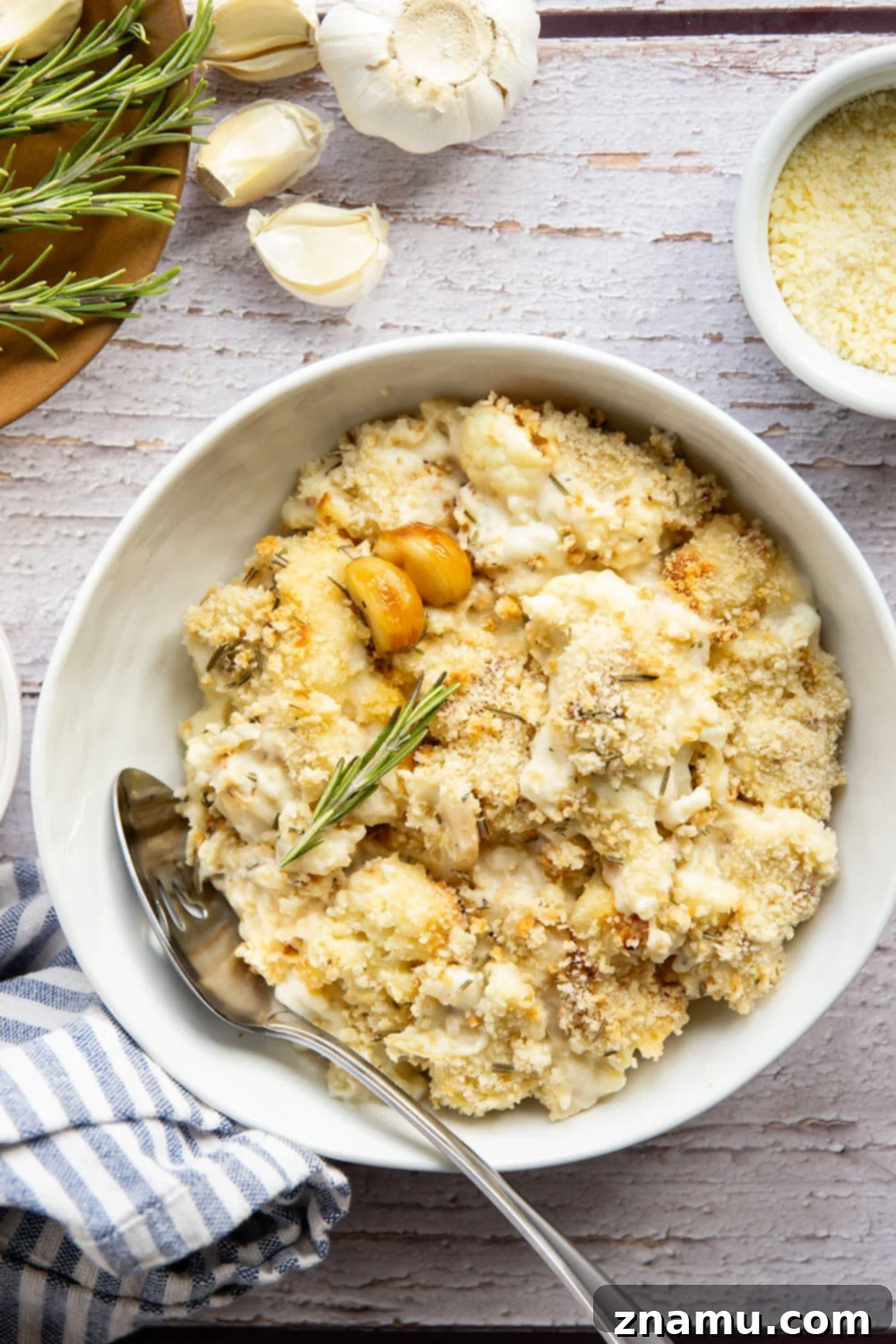 Garlicky Cheesy Cauliflower Gratin 6 A serving of Roasted Garlic Cauliflower Au Gratin, garnished with fresh rosemary.