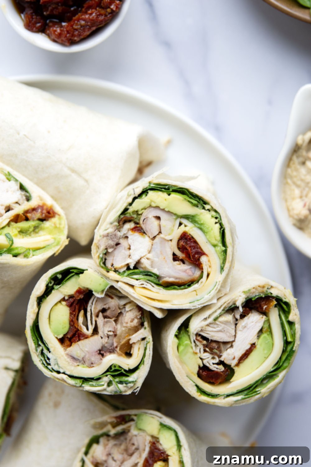Mediterranean Turkey Hummus Wrap with Sun-Dried Tomatoes 6 Delicious turkey hummus wrap showing a close-up of the fillings and a bite taken out.
