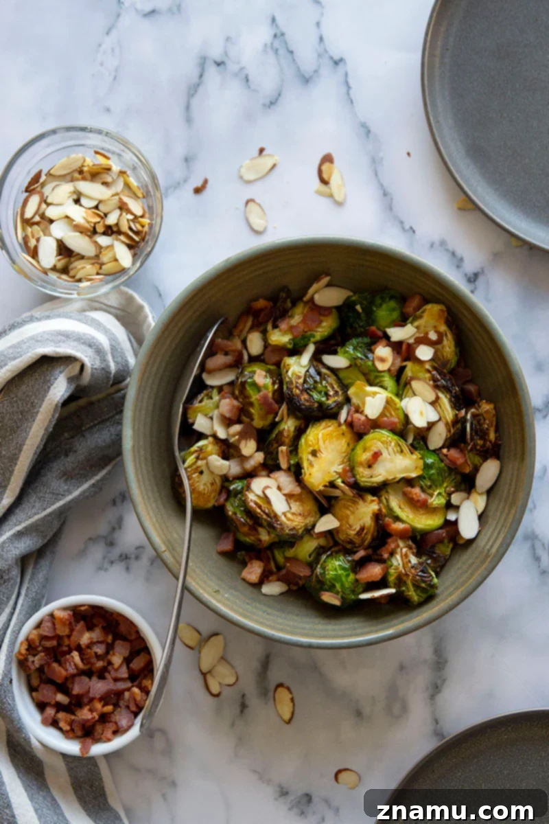 Your Thanksgiving Feast Roadmap 15 Crispy Air Fryer Brussels Sprouts, glistening with hot honey butter, sprinkled with red pepper flakes and served in a bowl.