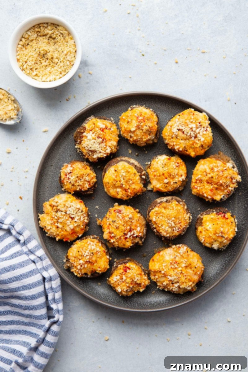 Your Thanksgiving Feast Roadmap 9 Golden brown Pimento White Cheddar Stuffed Mushrooms, fresh from the oven, garnished with parsley on a serving plate.