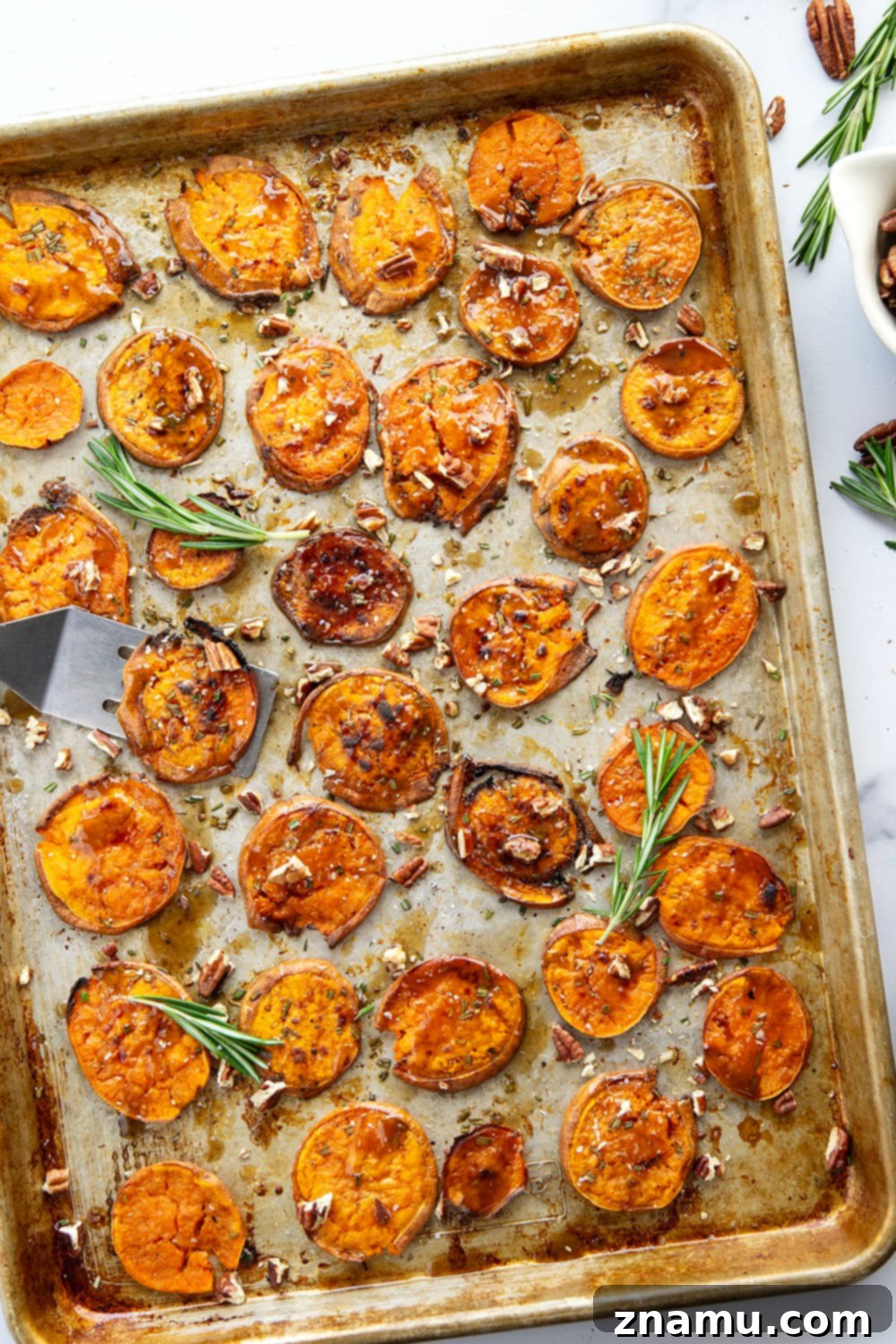 Sweet potato slices arranged on a baking sheet before roasting.