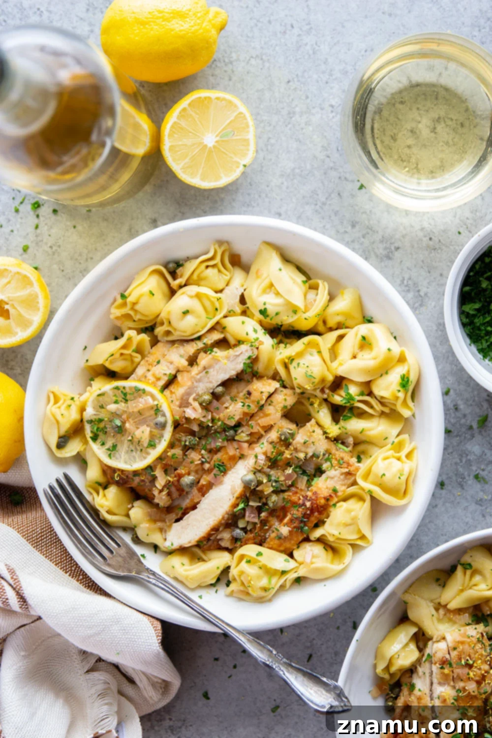 Lemon Caper Chicken Tortellini 2 Juicy seared chicken cutlets served over tender cheese tortellini with a flavorful lemon caper sauce, garnished with fresh parsley.