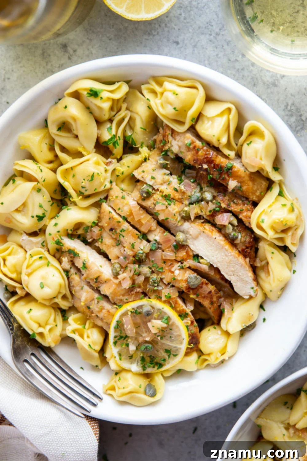 Lemon Caper Chicken Tortellini 4 Overhead shot of skillet chicken piccata tortellini with fresh parsley garnish, ready to be served.