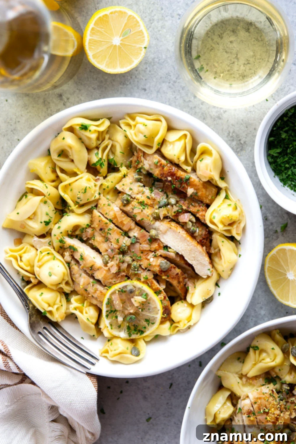 Lemon Caper Chicken Tortellini 6 A serving of Chicken Piccata Tortellini, showcasing the golden chicken, tender tortellini, and rich lemon caper sauce, garnished with fresh herbs.