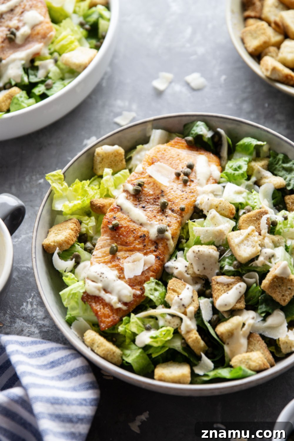 Golden-Crisp Salmon Caesar with Slow-Roasted Garlic Dressing 3 Buttery seared salmon fillets are the perfect meat pairing in this protein-packed seared salmon Caesar salad that features a creamy roasted garlic dressing on top.