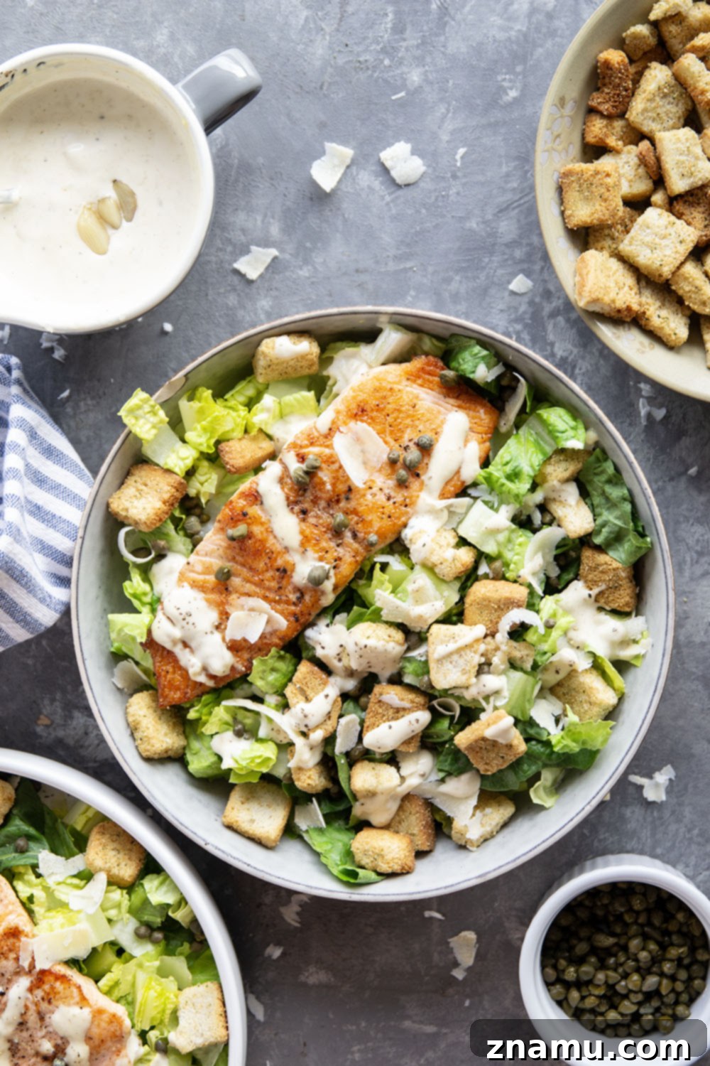 Golden-Crisp Salmon Caesar with Slow-Roasted Garlic Dressing 4 Buttery seared salmon fillets are the perfect meat pairing in this protein-packed seared salmon Caesar salad that features a creamy roasted garlic dressing on top.