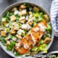 Buttery seared salmon fillets are the perfect meat pairing in this protein-packed seared salmon Caesar salad that features a creamy roasted garlic dressing on top.