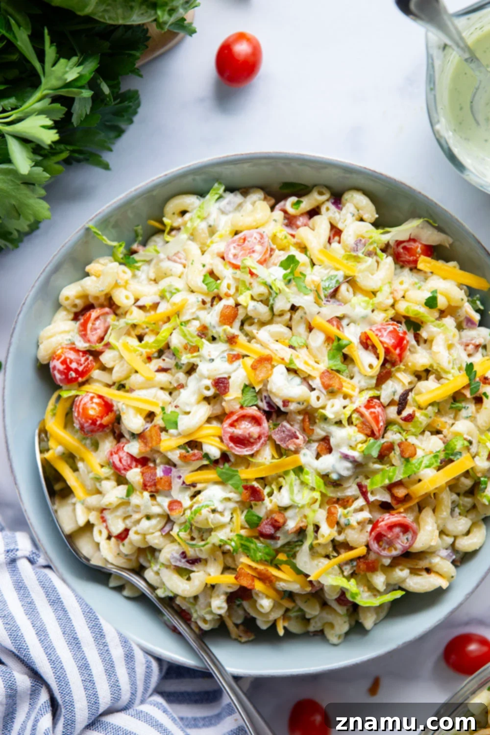 This BLT macaroni salad is packed with crispy bacon, shredded lettuce, juicy tomatoes, lots of shredded cheddar, and tossed in a perfectly creamy homemade herb ranch dressing.