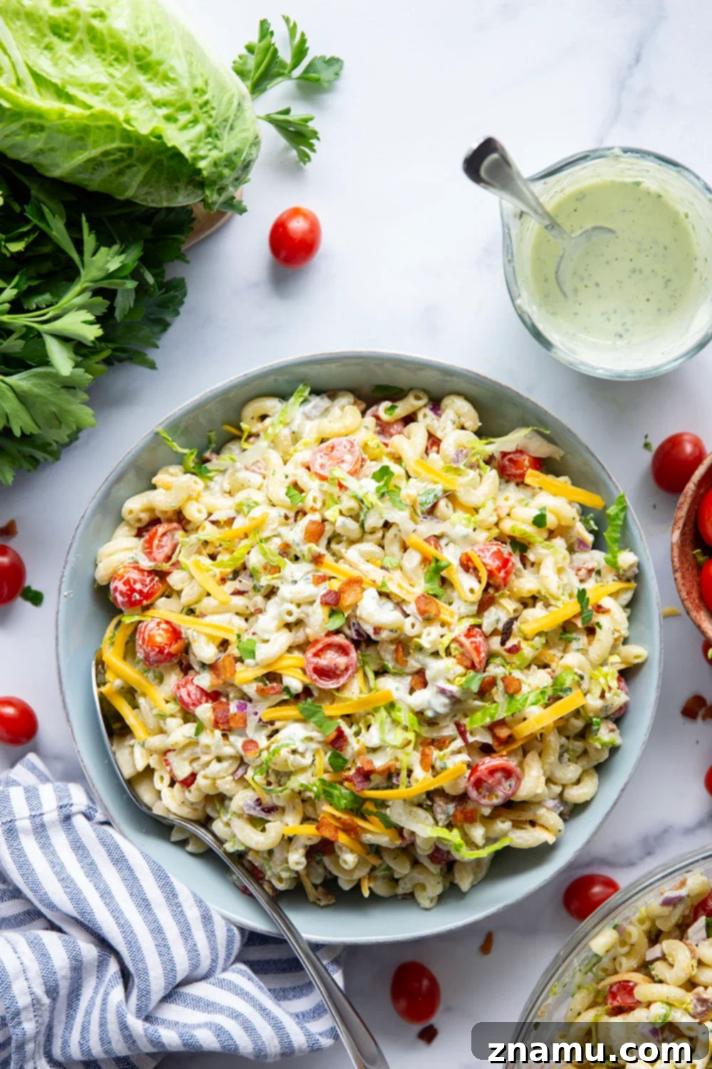 This BLT macaroni salad is packed with crispy bacon, shredded lettuce, juicy tomatoes, lots of shredded cheddar, and tossed in a perfectly creamy homemade herb ranch dressing.