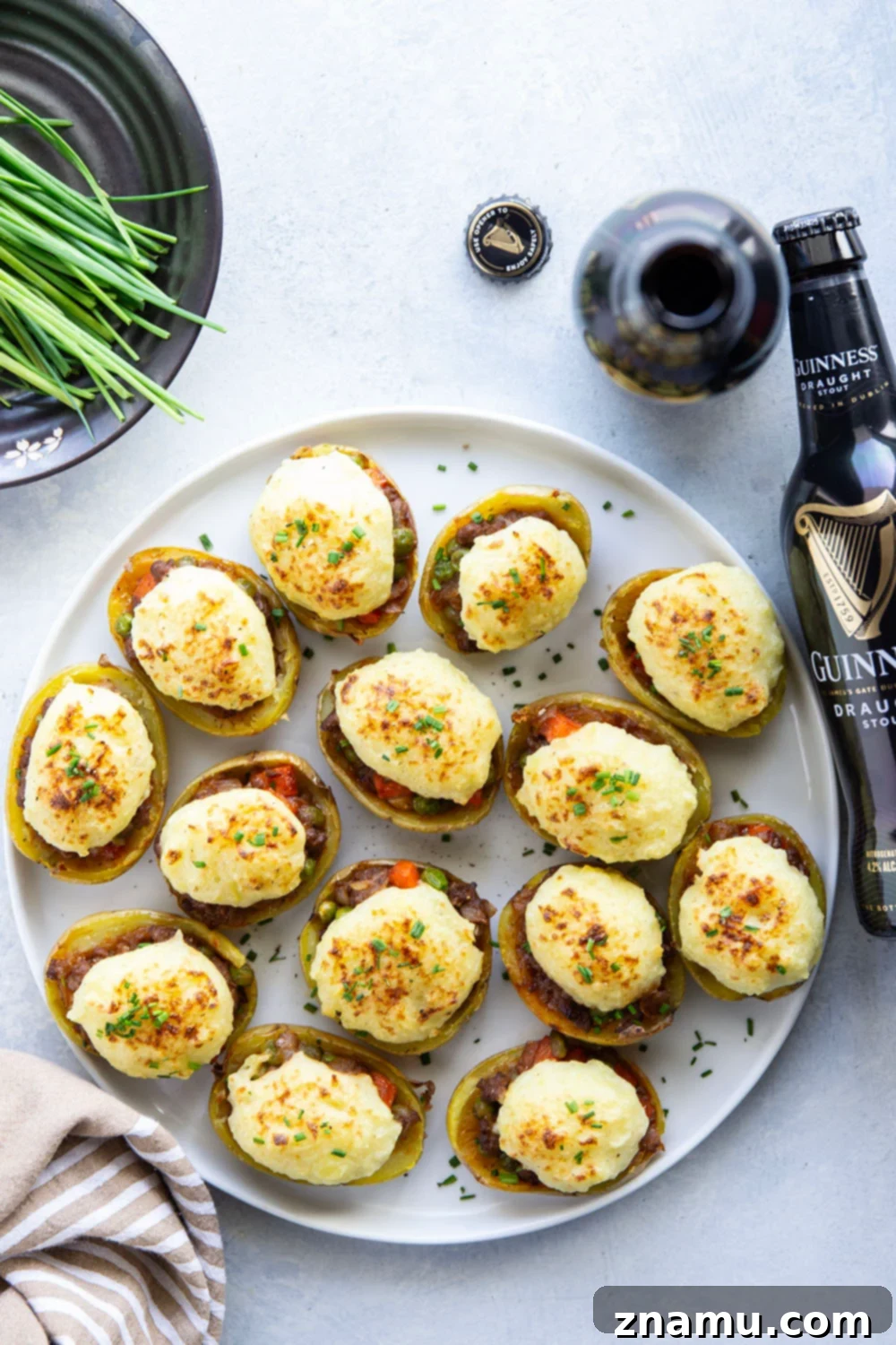 Guinness Shepherd's Pie Loaded Potato Skins 3 Close-up of Guinness Shepherd's Pie Potato Skins, showing the golden-brown mashed potato topping and the hearty filling peeking out, ideal for gatherings.