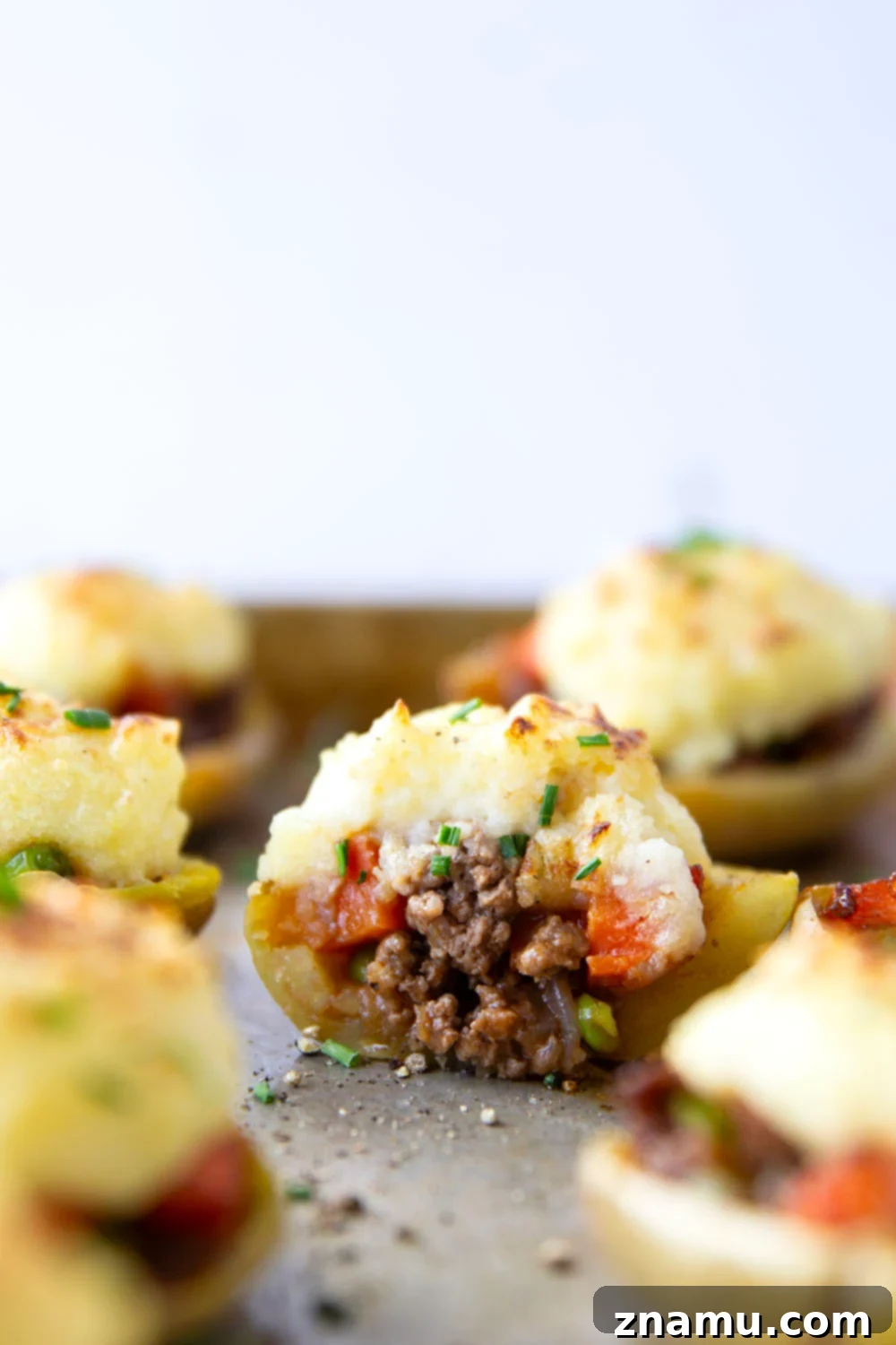 Guinness Shepherd's Pie Loaded Potato Skins 4 Arrangement of Guinness Shepherd's Pie Potato Skins, showcasing the rich filling and beautifully piped mashed potato topping, perfect for a festive spread.