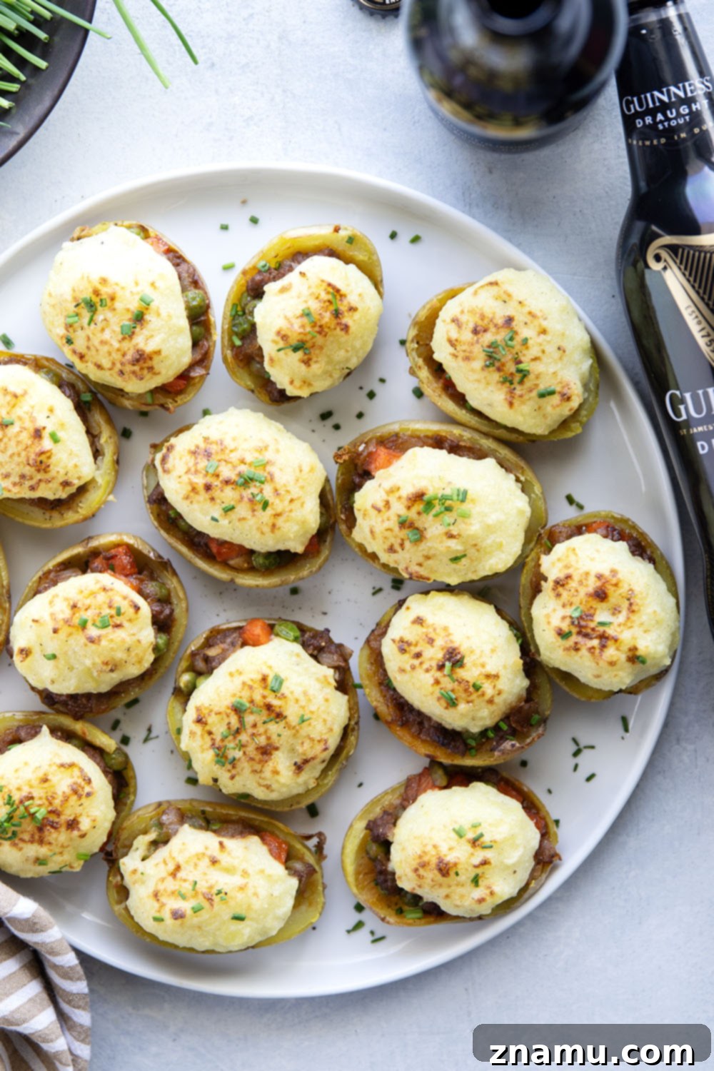 Guinness Shepherd's Pie Loaded Potato Skins 6 Three Guinness Shepherd's Pie Potato Skins garnished with fresh chives, presented on a white plate ready to be served.