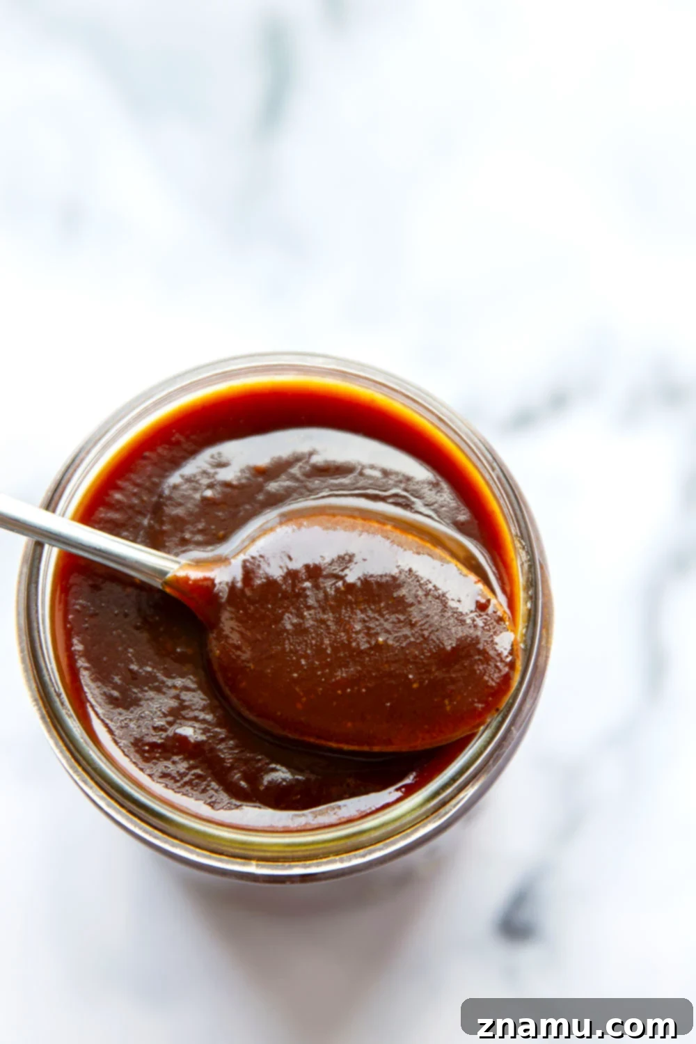 A bowl of homemade BBQ sauce with a small brush, ready for application on cooked food.