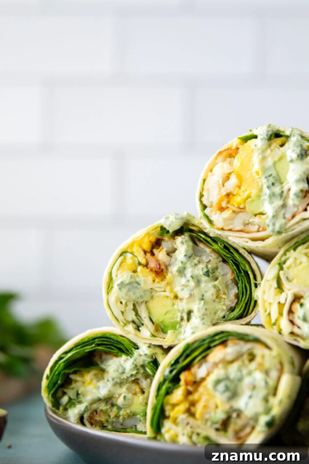 Vibrant Green Goddess Breakfast Burritos 2 Delicious Green Goddess Breakfast Burritos with fluffy eggs, crispy hashbrowns, and fresh greens.