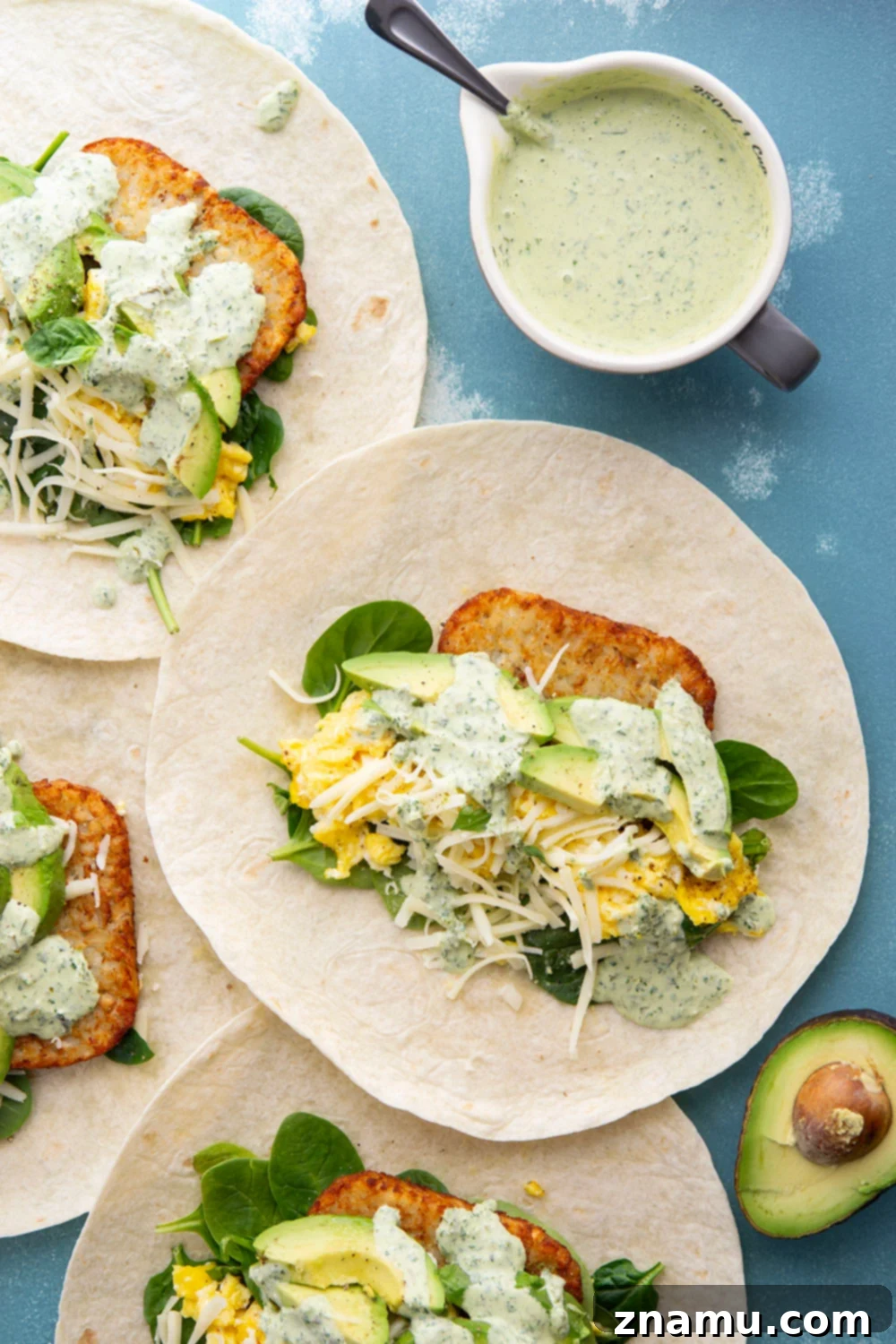 Vibrant Green Goddess Breakfast Burritos 3 Close-up of a Green Goddess Breakfast Burrito, highlighting the fresh spinach, avocado, and creamy sauce.