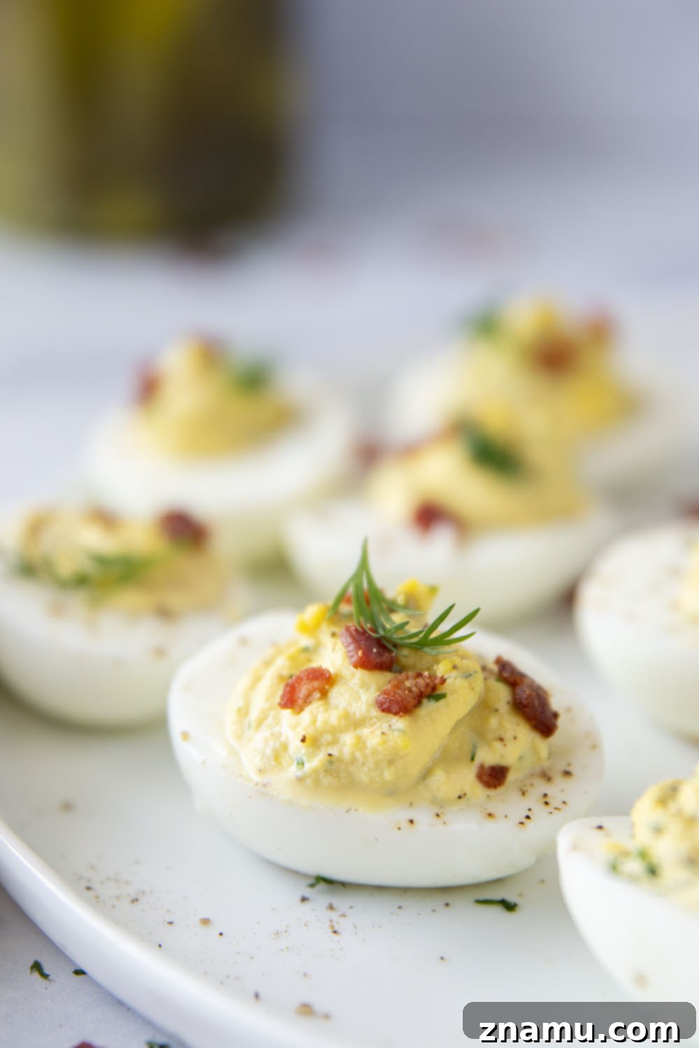 Zesty Bacon Dill Pickle Deviled Eggs 5 Ingredients for dill pickle deviled eggs laid out on a wooden surface.