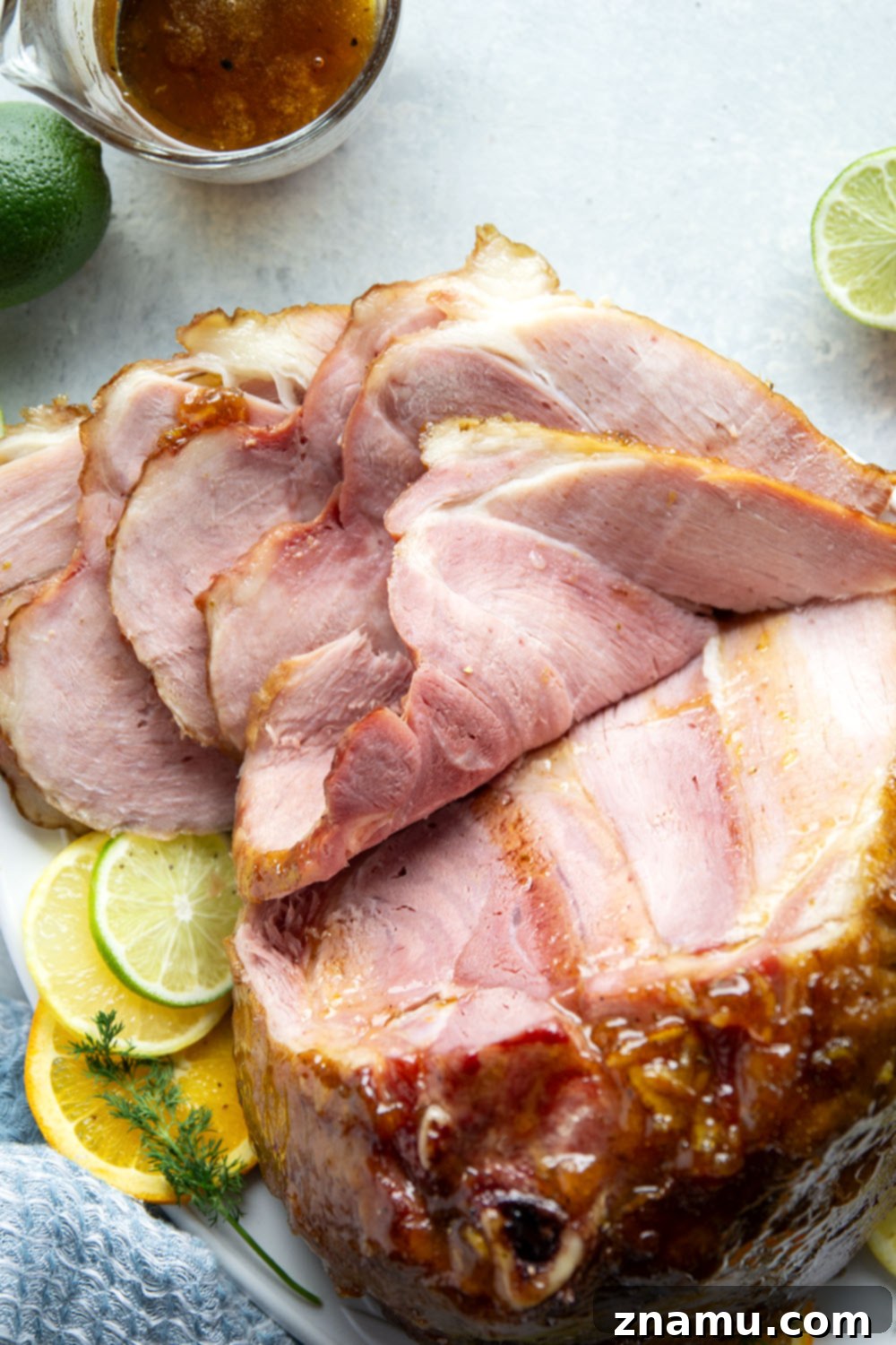 Sweet and Tangy Glazed Ham 4 A slice of honey citrus glazed ham on a white plate, showcasing its tender texture and the glossy glaze, ready to be enjoyed.