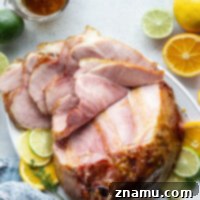 Sweet and Tangy Glazed Ham 8 Honey Citrus Glazed Ham on a platter, ready for serving.