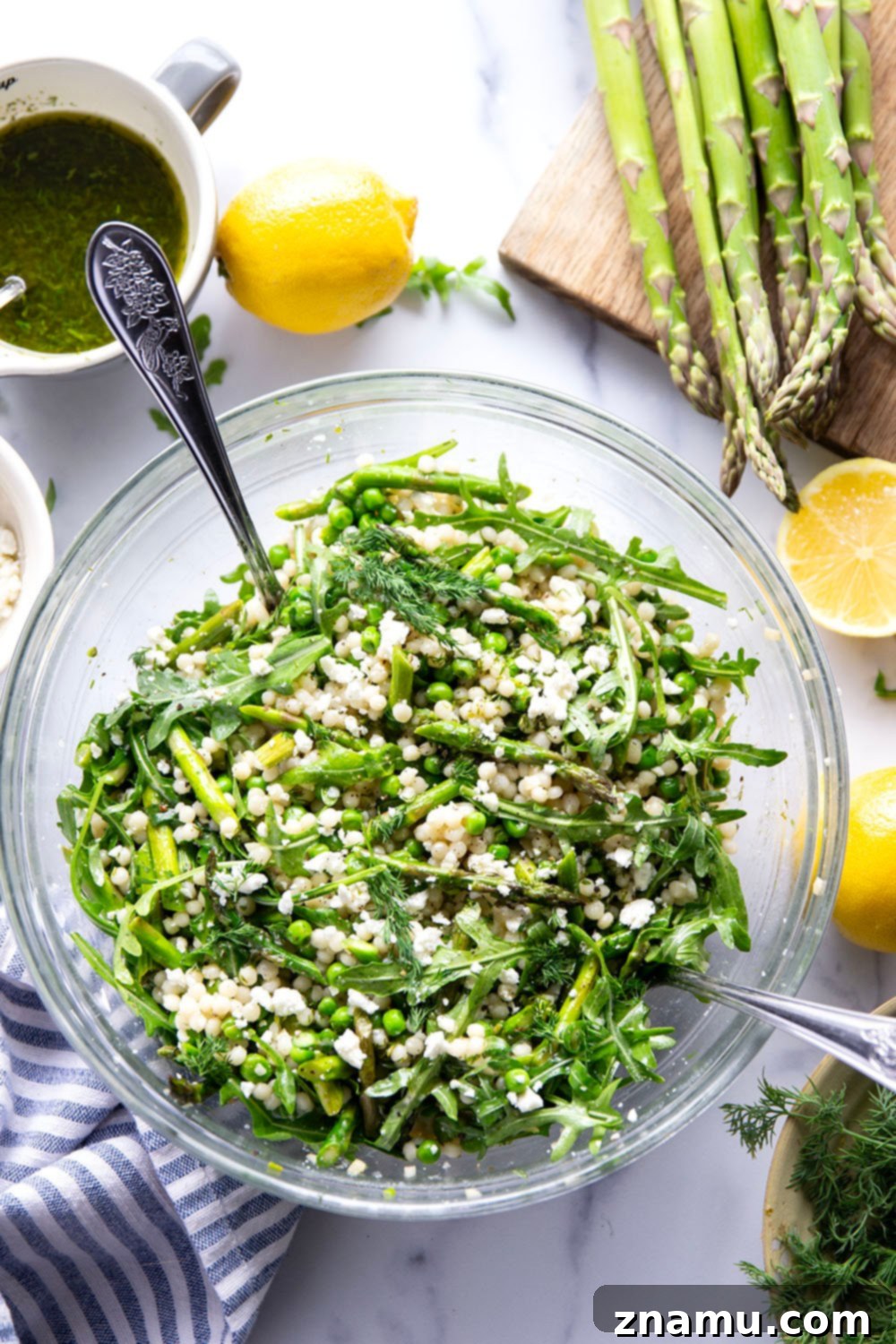 Spring Asparagus Couscous Salad with Zesty Dill Vinaigrette 4 A large bowl of fresh Asparagus Couscous Salad, showcasing the bright green vegetables and the creamy feta cheese, ready for serving.