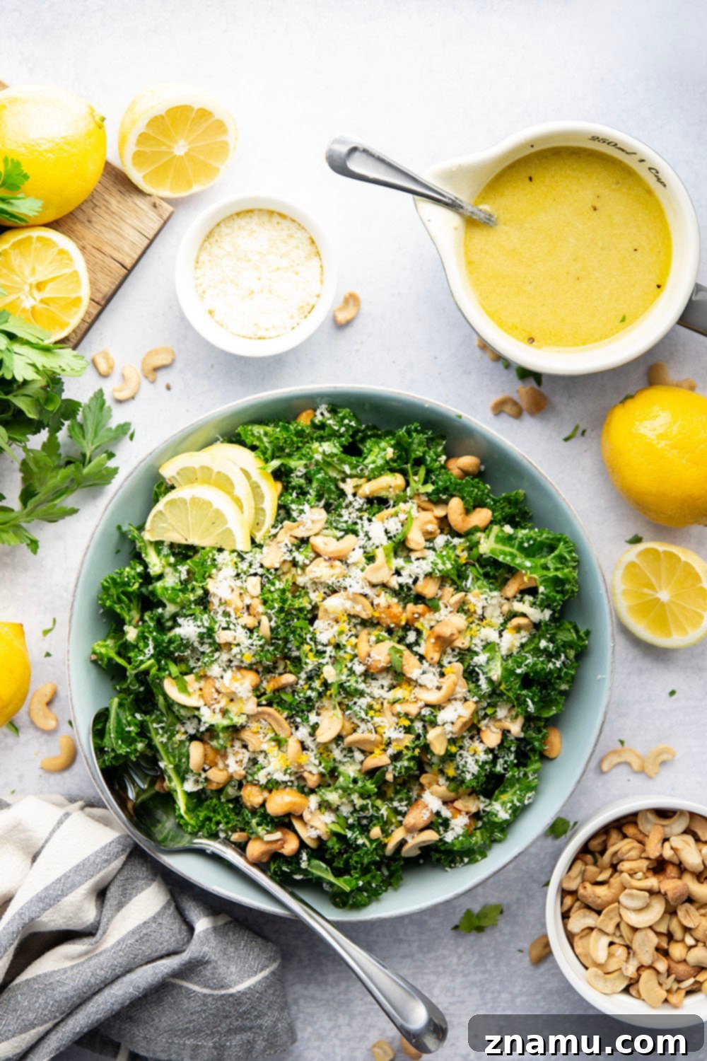 Lemon Kissed Asiago Cashew Kale 6 A close-up shot of the fully assembled Asiago Lemon Cashew Kale Salad, with a fork ready to pick up a delicious bite.