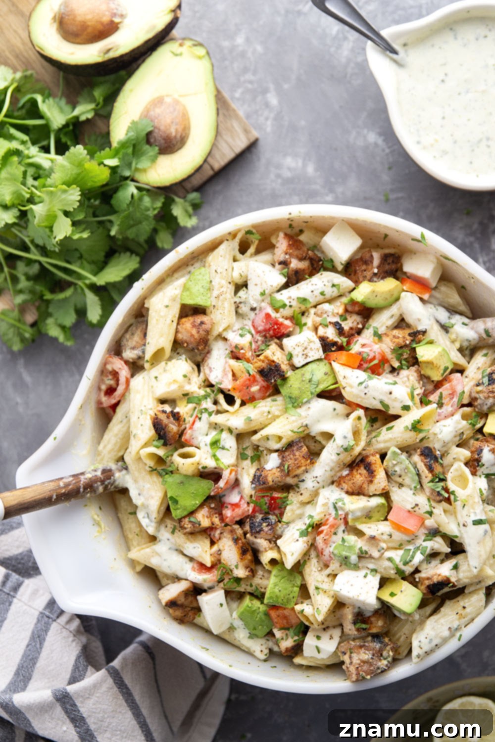 Close-up of the Blackened Chicken Avocado Pasta Salad, showing cubed chicken, avocado, tomatoes, and mozzarella mixed with pasta.