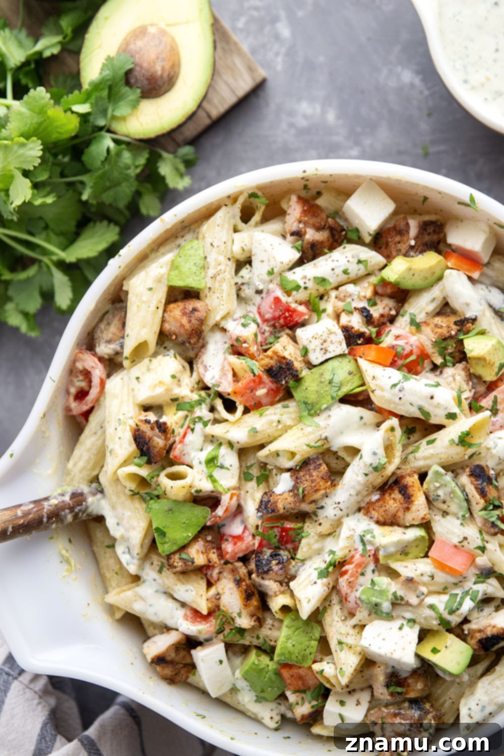 A serving of Blackened Chicken Avocado Pasta Salad with fresh cilantro garnish, ready to enjoy.