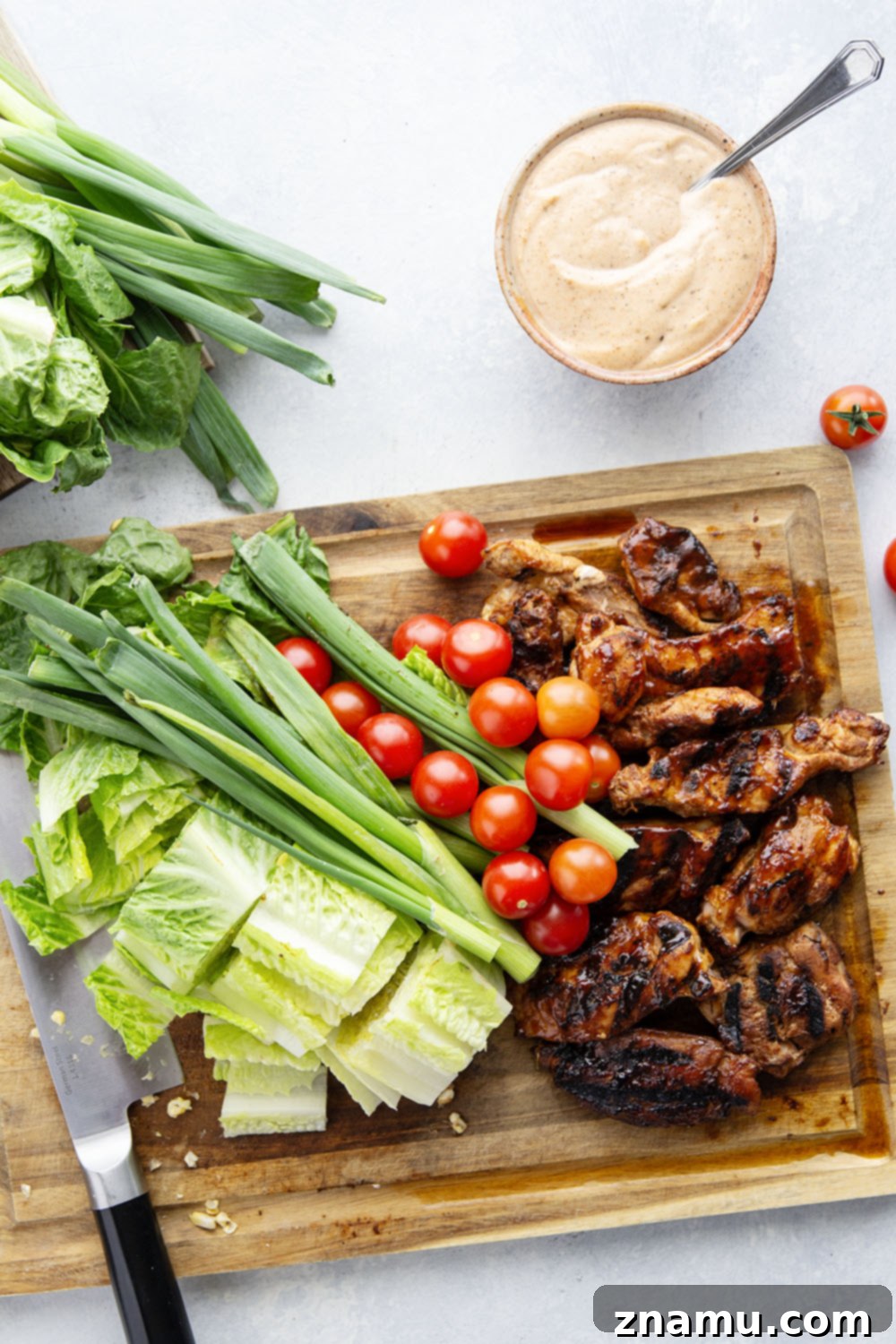 Ingredients for the Grilled Sweet Corn BBQ Chicken Chopped Salad laid out on a wooden cutting board.