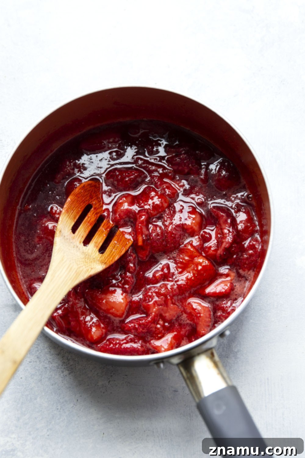 Luscious Homemade Strawberry Sauce 4 Strawberry sauce simmering gently in a saucepan, creating a rich and vibrant color.