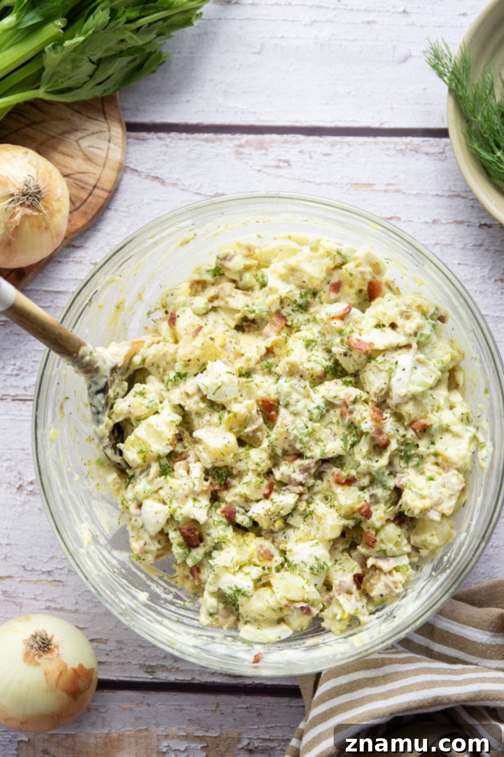Grandma's Potato Salad 4 A bowl of Old Fashioned Potato Salad garnished with fresh dill and additional crispy bacon, highlighting its appealing presentation.