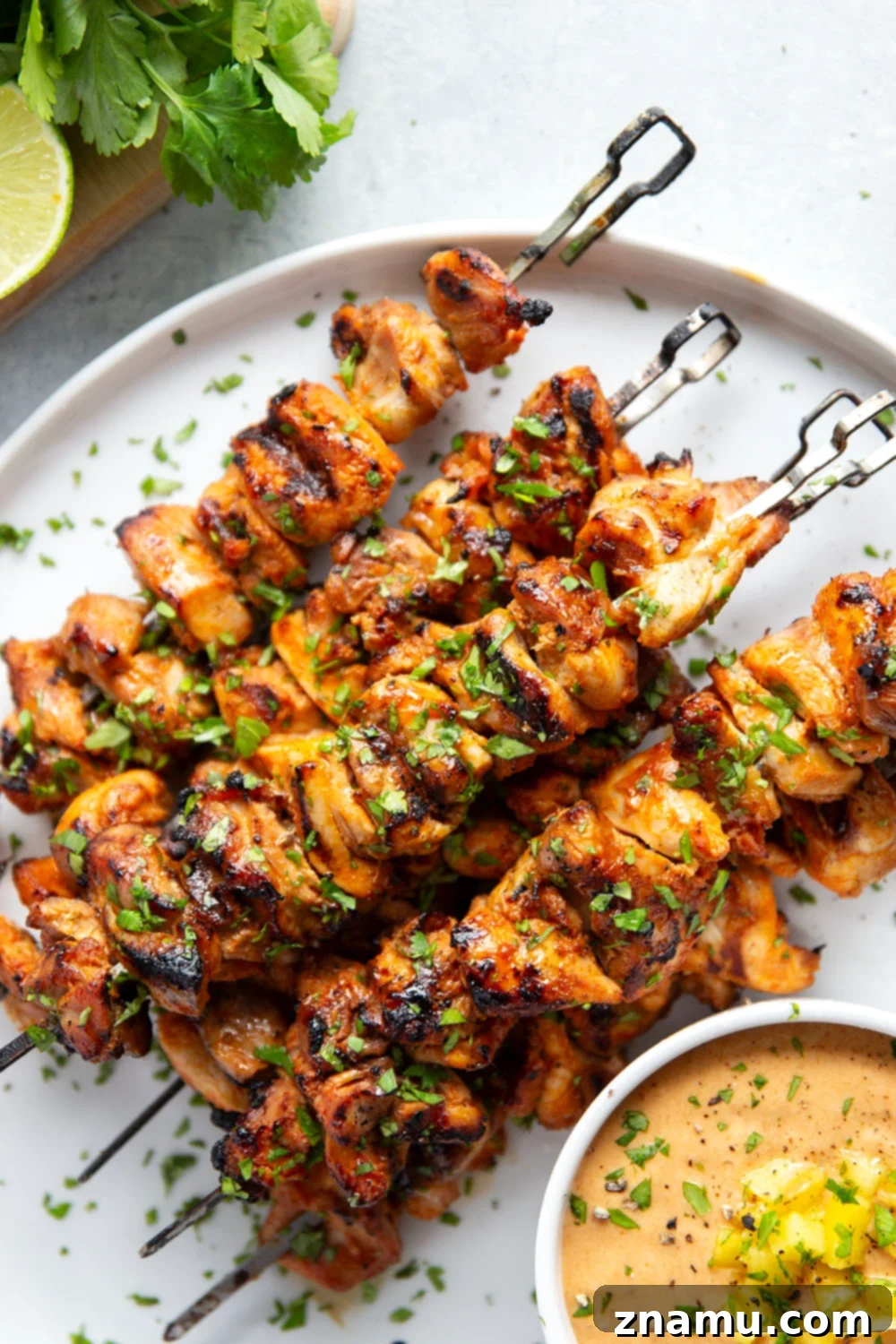 Mango Glazed Thai Chicken Skewers 5 Uncooked marinated chicken cubes on skewers, ready for grilling.