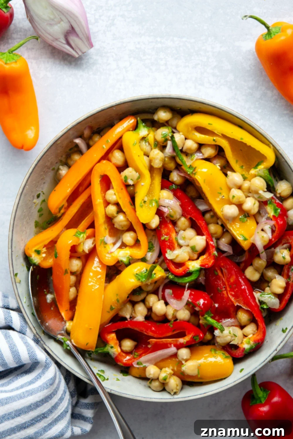Zesty Grilled Chickpea and Sweet Pepper Medley 3 Close-up of marinated chickpeas and colorful mini sweet peppers in a mixing bowl with fresh herbs and lemon slices.