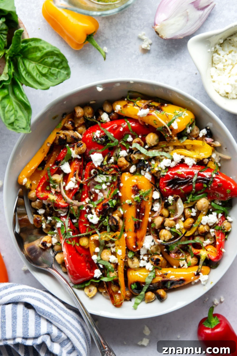 Zesty Grilled Chickpea and Sweet Pepper Medley 6 A bowl of grilled marinated chickpeas and sweet peppers on a wooden table, ready to be served.
