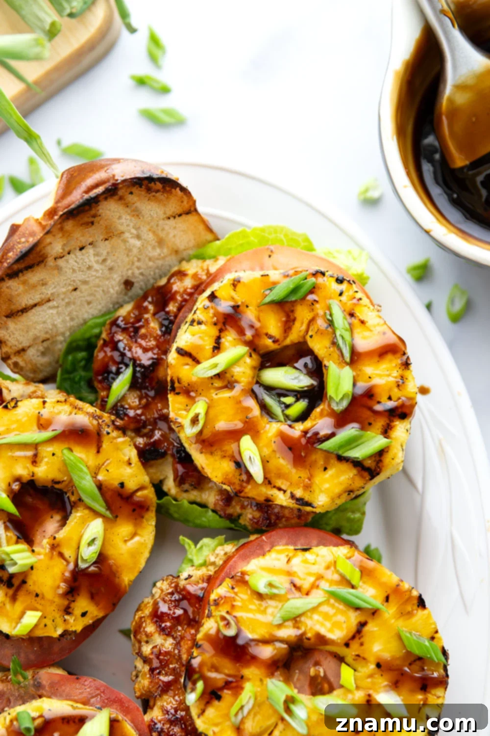 These teriyaki pineapple chicken burgers feature juicy chicken patties brushed with a homemade teriyaki sauce and grilled alongside sweet pineapple rings all piled into an unforgettable burger!