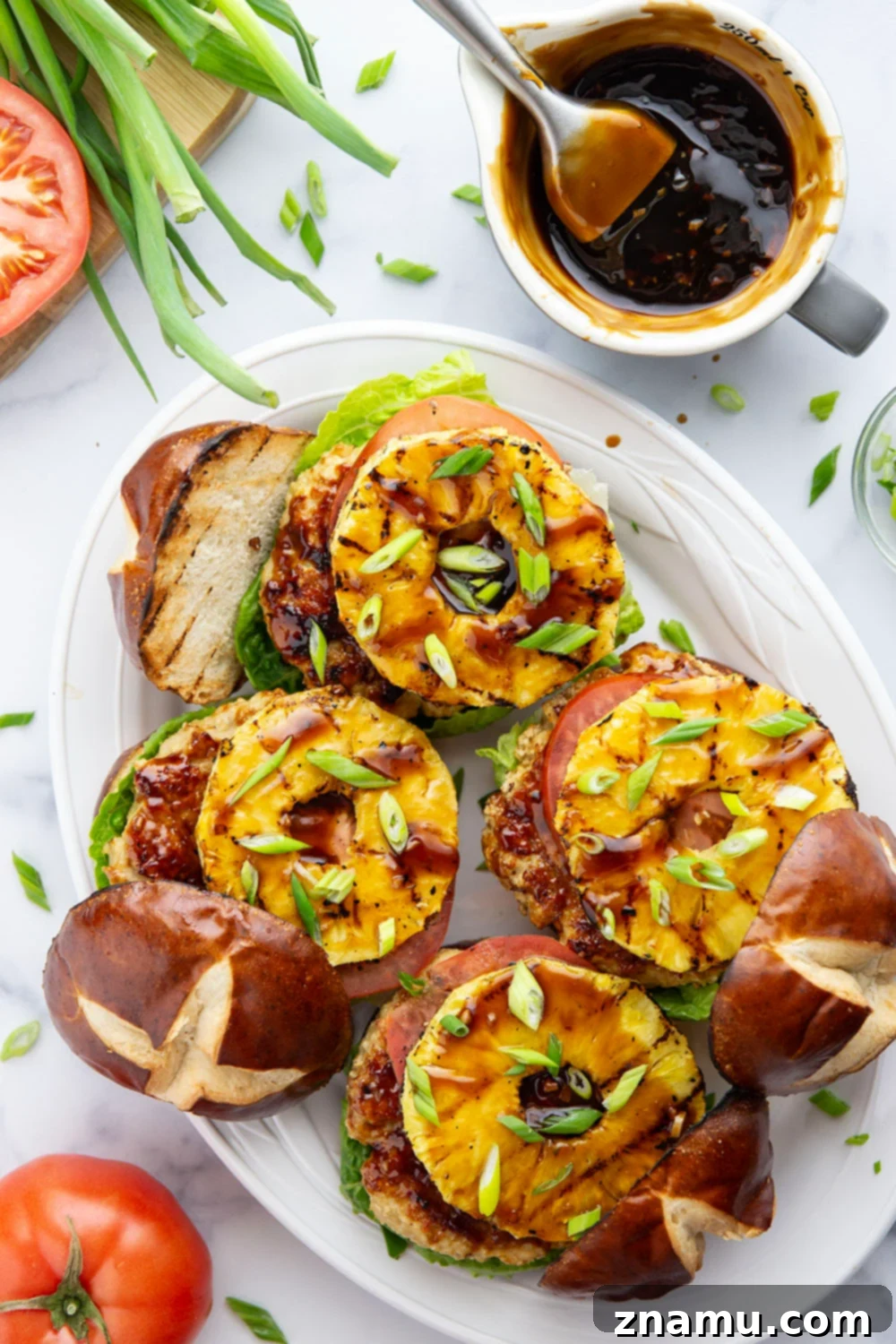These teriyaki pineapple chicken burgers feature juicy chicken patties brushed with a homemade teriyaki sauce and grilled alongside sweet pineapple rings all piled into an unforgettable burger!