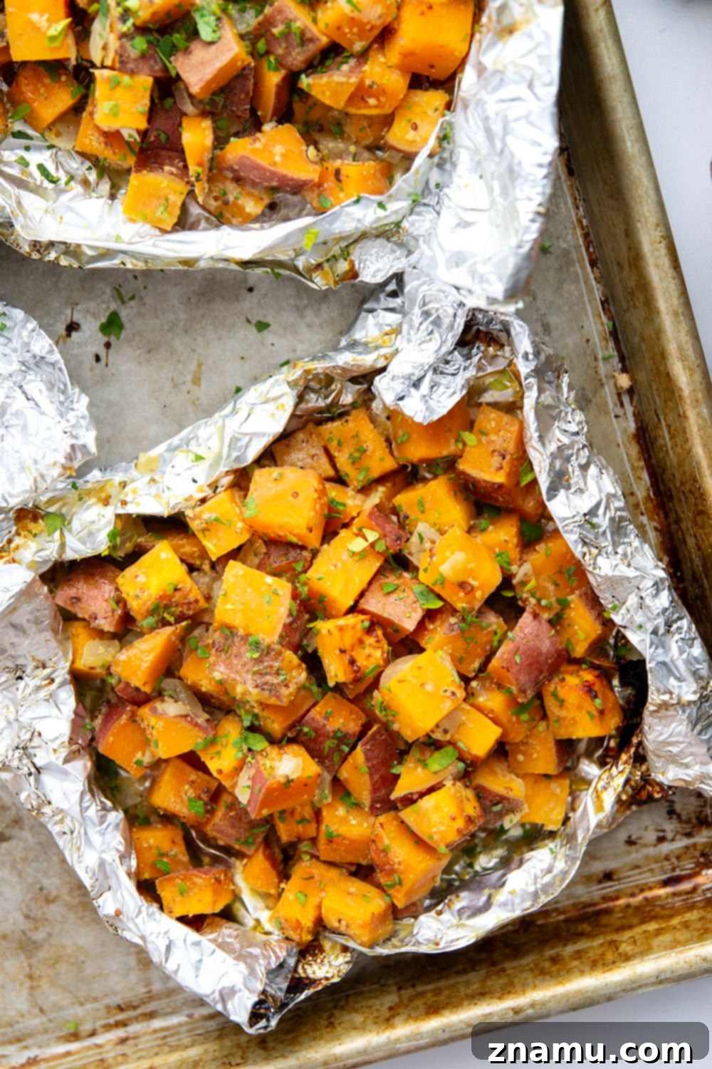 Plate of honey mustard grilled sweet potatoes, garnished with fresh parsley.