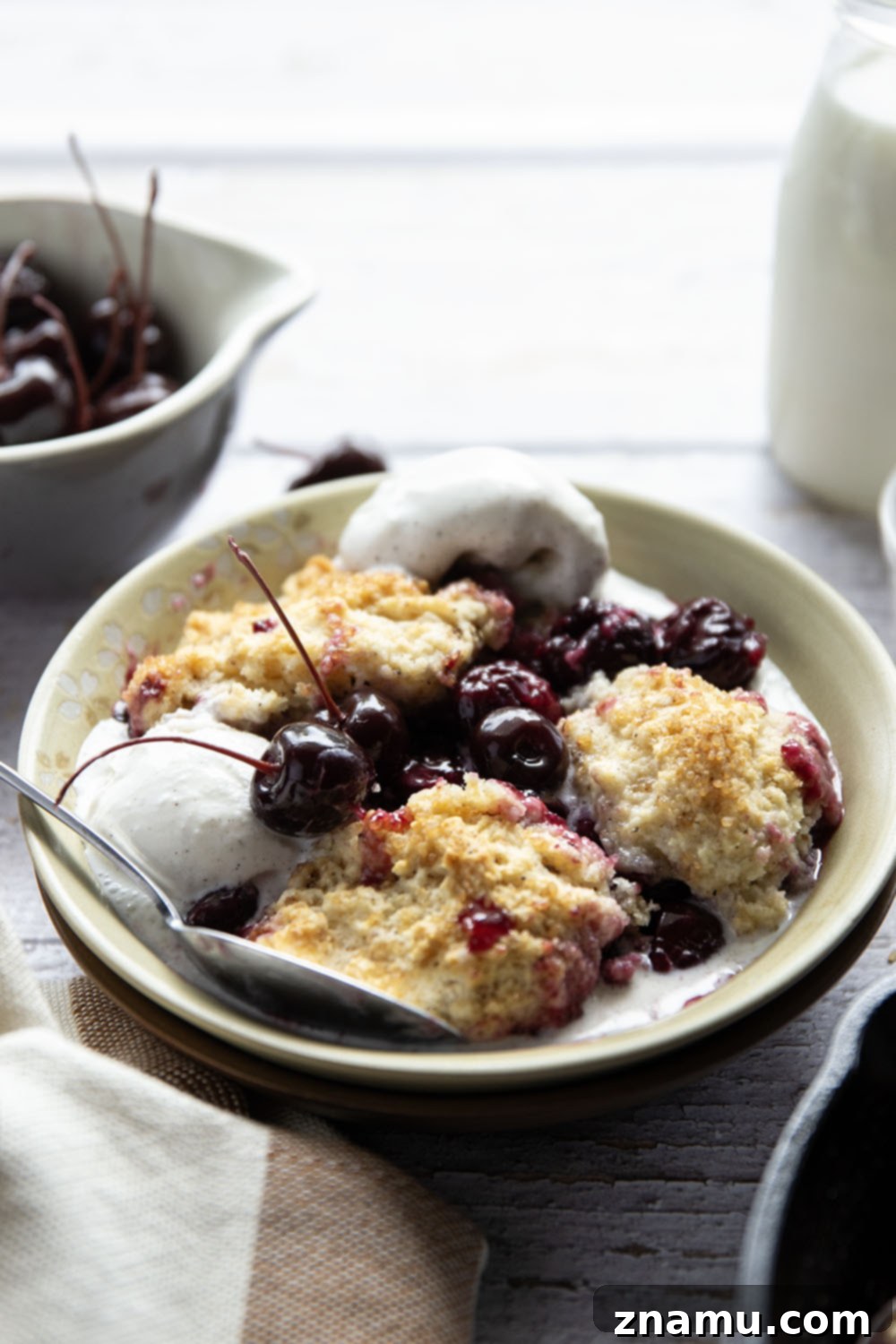 Sweet Cherry & Toasted Butter Cobbler 6 A serving of browned butter cherry cobbler topped with a melting scoop of vanilla ice cream.