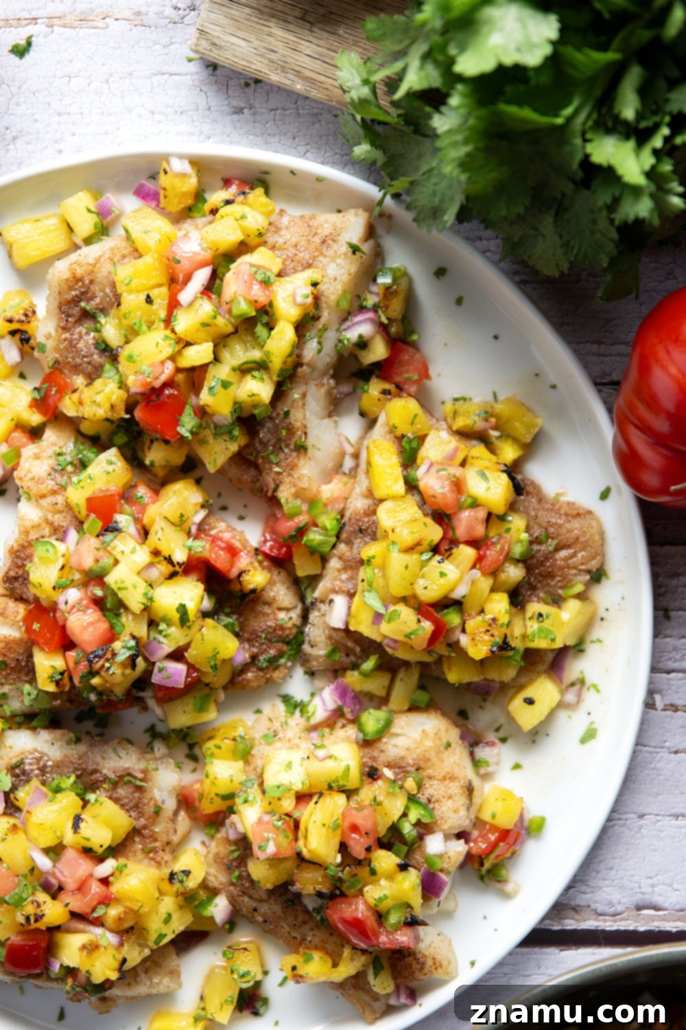 Tropical Jerk Cod with Sweet Pineapple Salsa 5 Fresh ingredients for Jerk Cod and Pineapple Salsa, including spices, cod, pineapple, and vegetables.