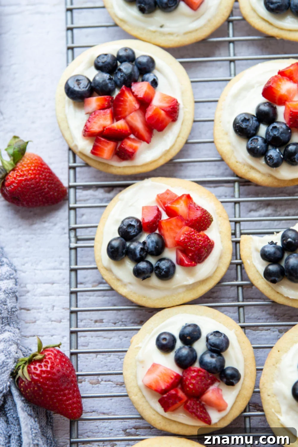 Star-Spangled Fruit Pizza Bites 4 These fruit pizzas feature soft sugar cookies topped with a cream cheese frosting and fresh blueberries and strawberries for a fun 4th of July dessert!