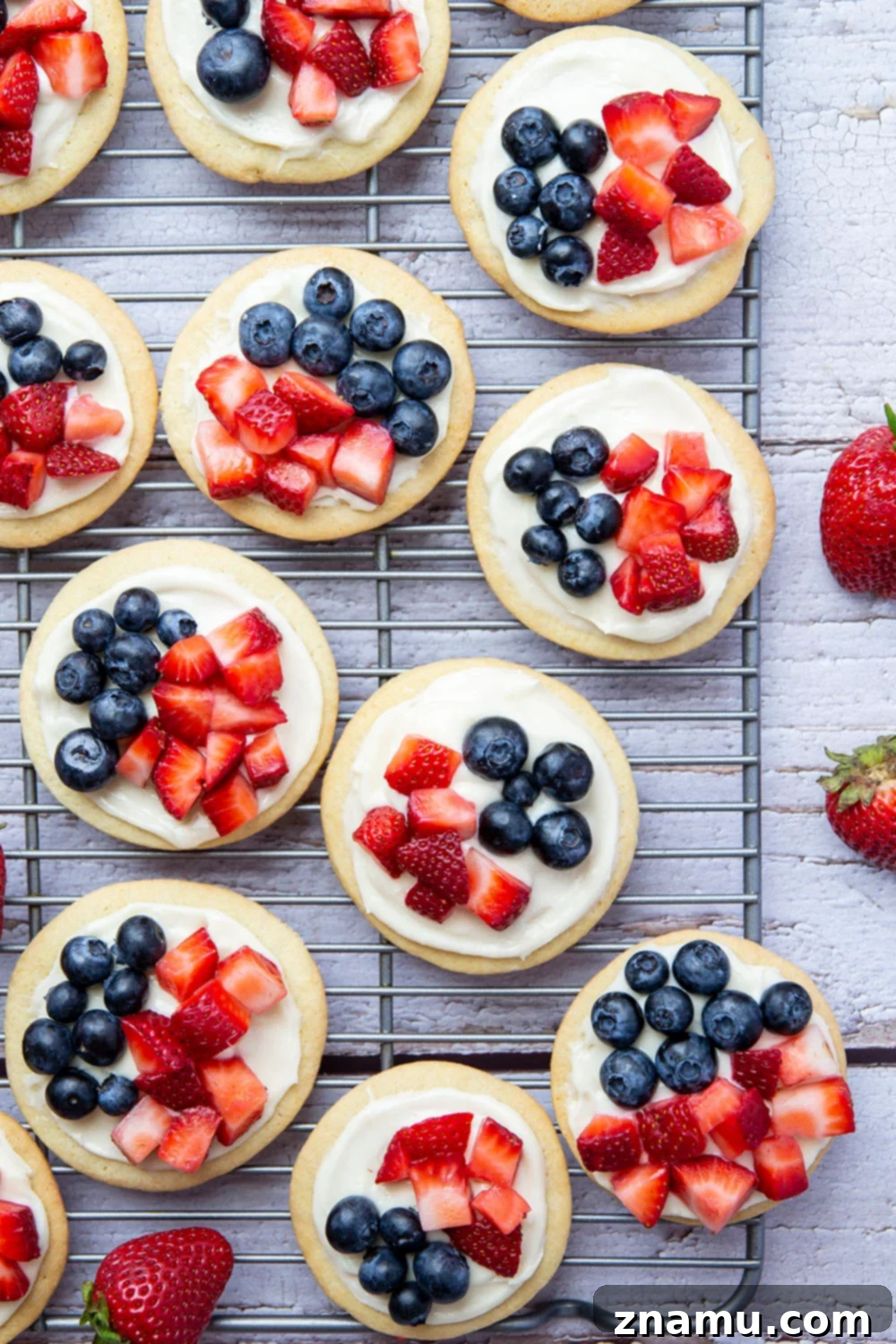 Star-Spangled Fruit Pizza Bites 5 These fruit pizzas feature soft sugar cookies topped with a cream cheese frosting and fresh blueberries and strawberries for a fun 4th of July dessert!