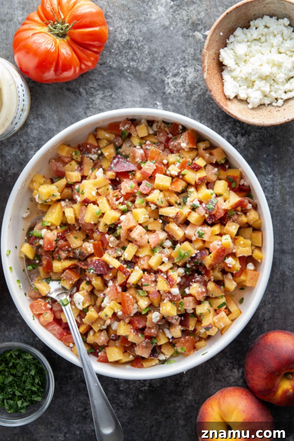 Artful arrangement of grilled chicken ingredients including peaches, feta, and tahini