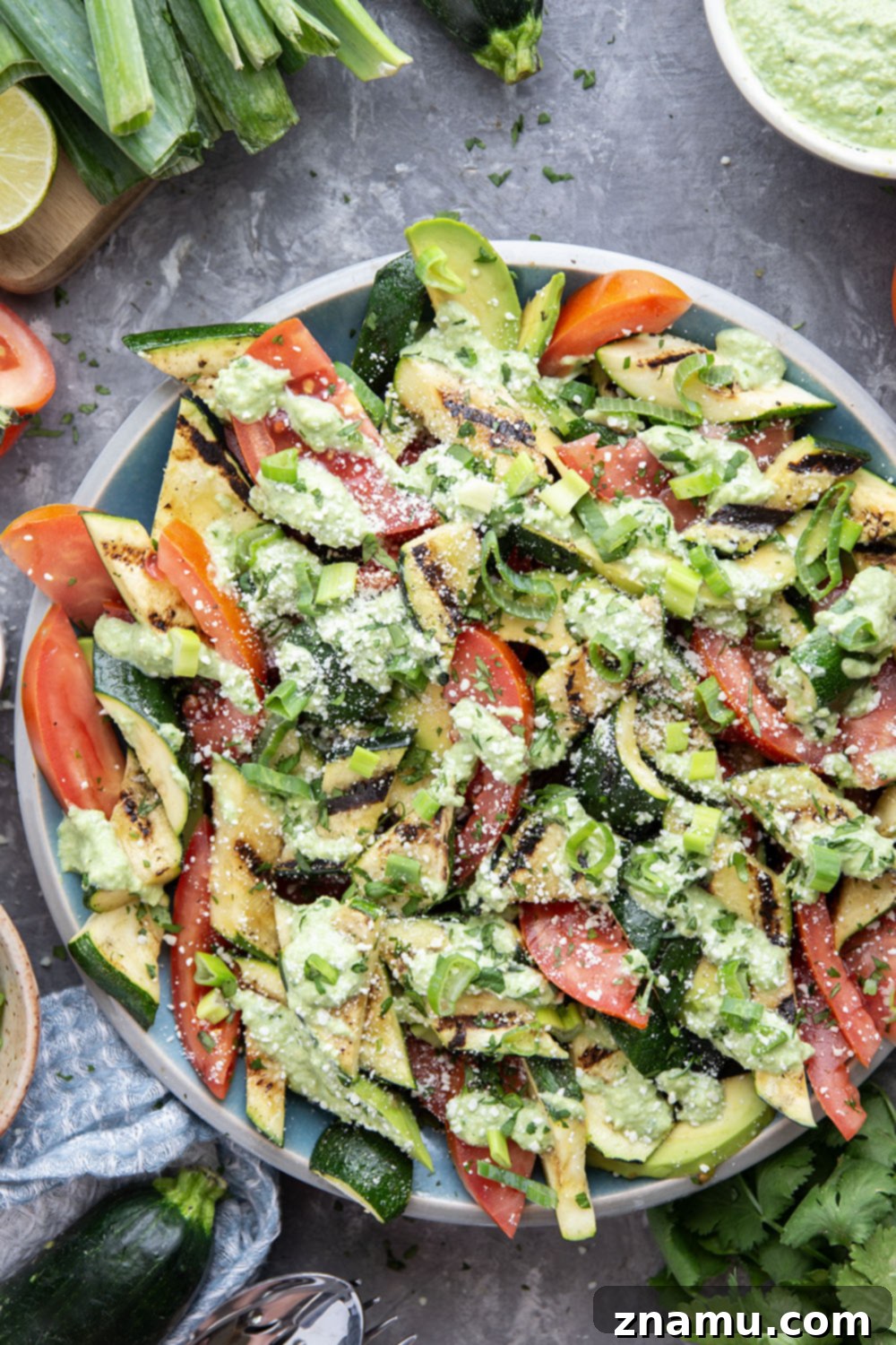 Smoky Grilled Zucchini and Heirloom Tomato Salad with Creamy Avocado-Scallion Dressing 4 Close-up of grilled zucchini slices beautifully arranged on a platter, ready for salad assembly.