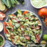 Tender zucchini is grilled until smoky and tossed with juicy summer tomatoes and a creamy avocado scallion dressing in this flavor-packed zucchini tomato salad.