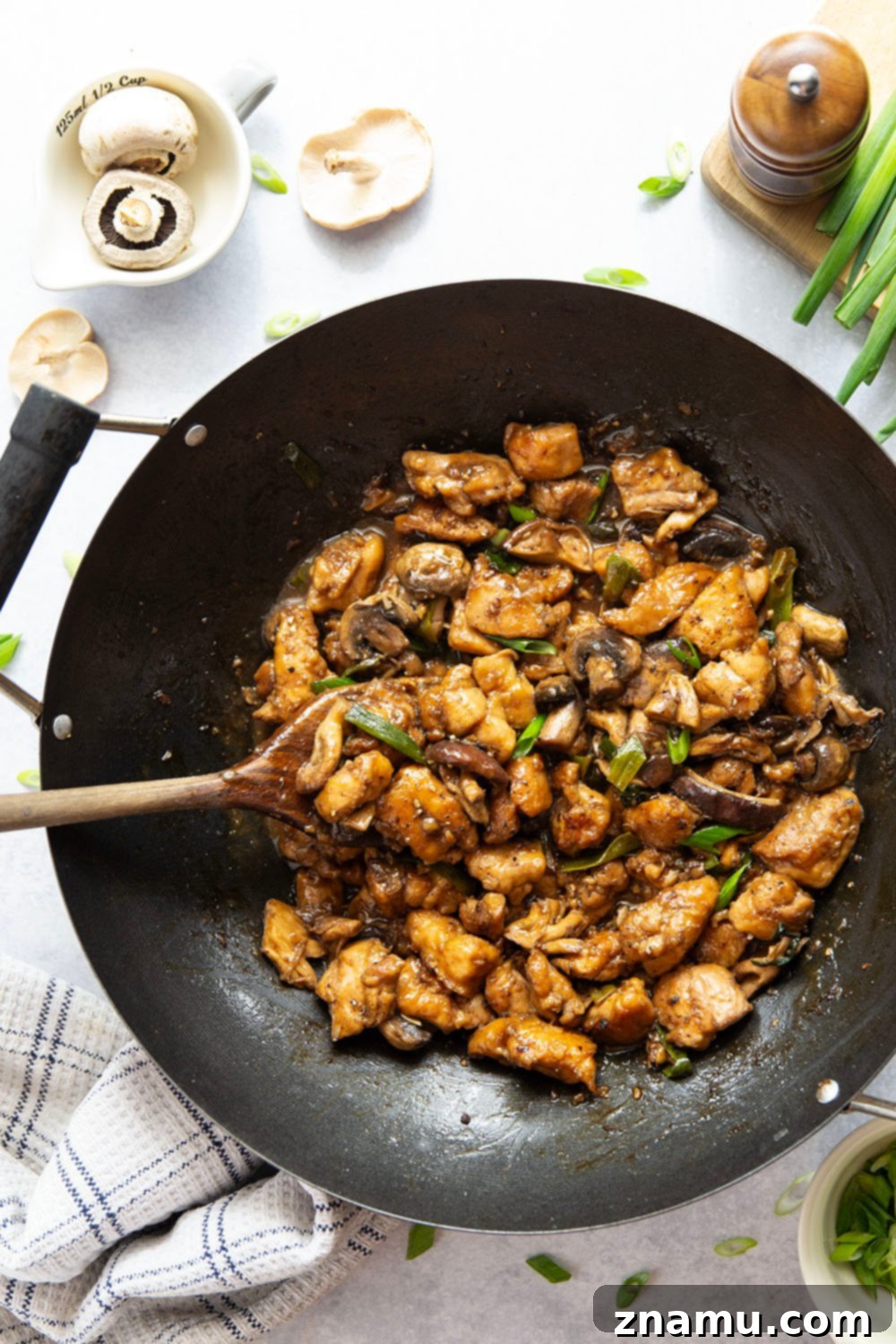 Close-up of golden pan-fried chicken and tender mushrooms in black pepper sauce