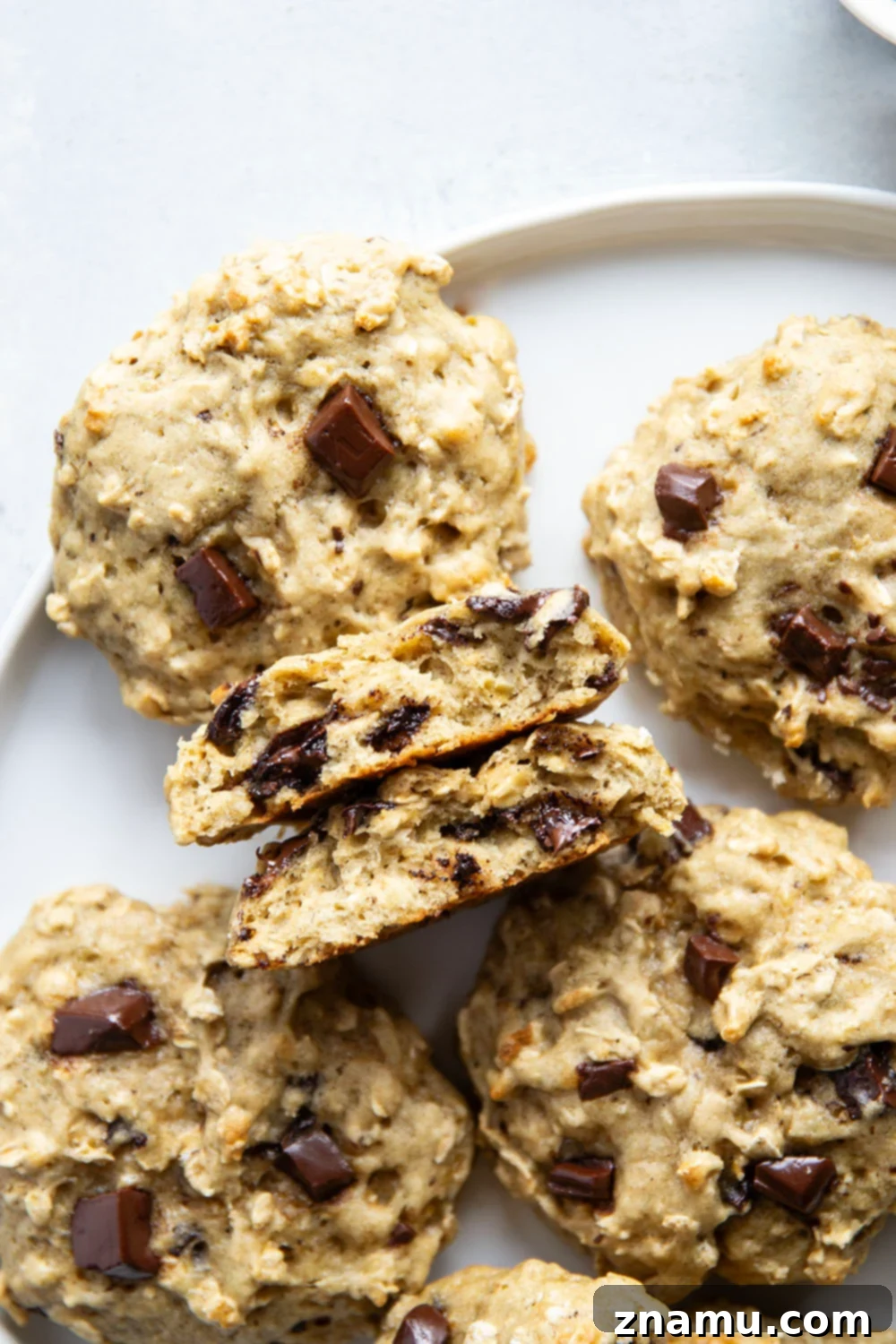 A hand reaching for a banana oatmeal breakfast cookie, emphasizing the grab-and-go convenience and deliciousness.
