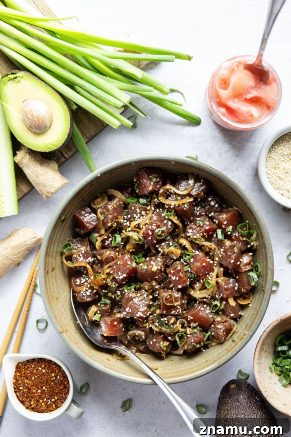 Close-up of marinated ahi tuna cubes glistening with ginger soy sauce, ready for a poke bowl