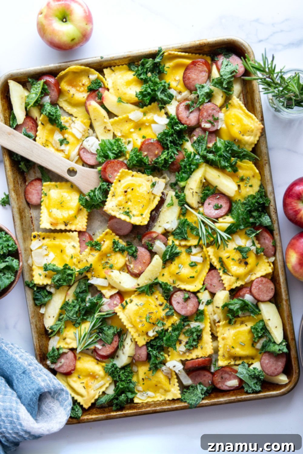 Sheet Pan Sausage, Apple, and Ravioli Bake 2 A vibrant sheet pan dinner featuring roasted cheese ravioli, sliced sausage, and apples, all glazed in a sweet maple mustard sauce, ready for a cozy fall meal.
