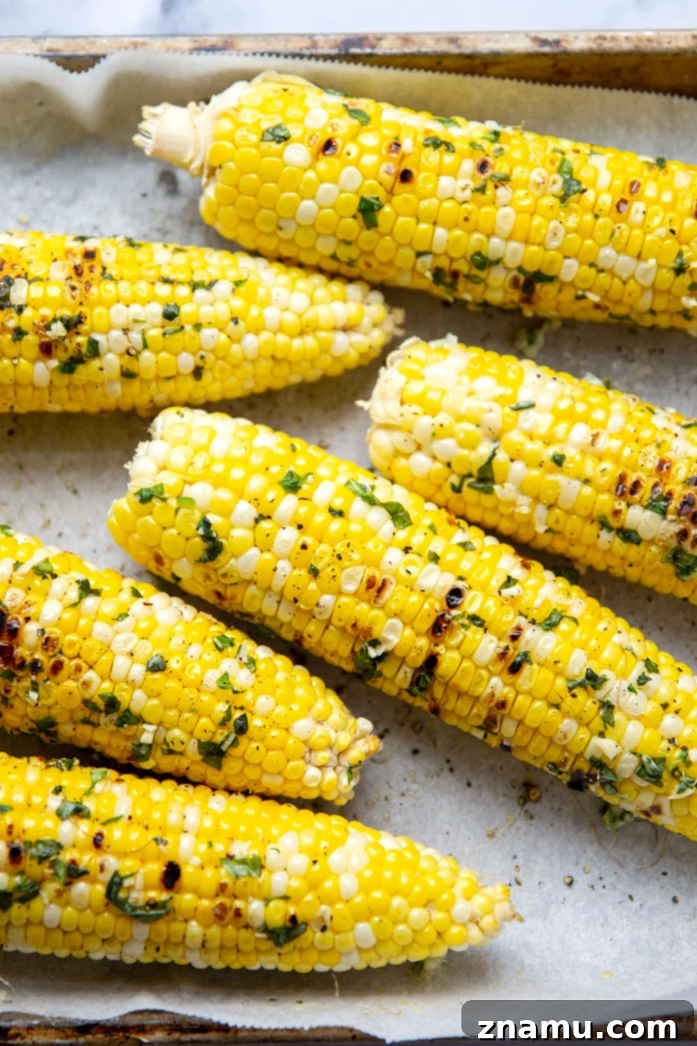 Irresistible Grilled Corn with Basil Butter 2 Grilled corn on the cob brushed with basil butter, perfectly sweet and tender